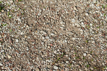 Background type view of small rocks on a pavement road. 