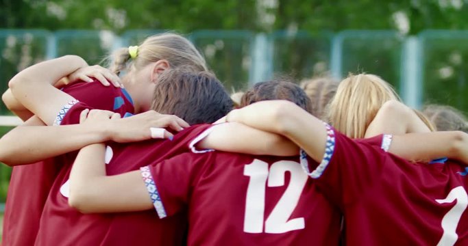 Teenager kid girls soccer players huddling up before game, cheering each other. 4K UHD 60 FPS SLO MO