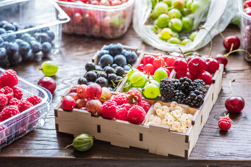 Colorful berries in wooden box on the table.