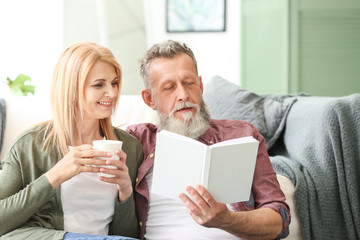 Happy elderly couple resting at home