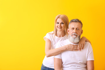 Beautiful elderly couple on color background