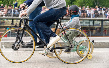 Father and son ride bicycles on walk along the Seine embankment in Paris