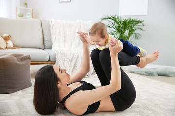 Mother training with cute little baby at home