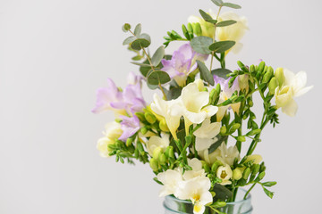 Bouquet of beautiful freesia flowers on light background