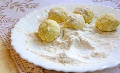 Cheesecakes, curd pancakes, cooking process. Prefab in flour on plate