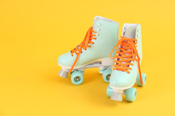 Vintage roller skates on color background