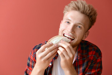 Man eating tasty taco on color background