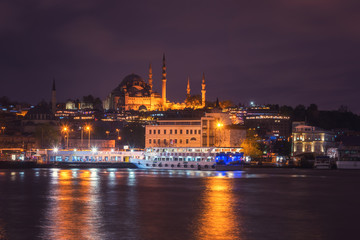 Fototapeta na wymiar Istanbul cityscape at night, scenic view of city in lights with Eminonu station (Eminönü iskulesi), Blue Mosque and Golden Horn bay, Bosphorus, Turkey. Outdoor travel background