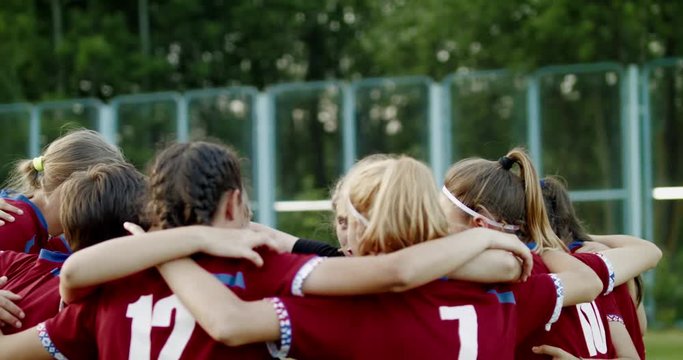 Teenager kid girls soccer players huddling up before game, cheering each other. 4K UHD 60 FPS SLO MO
