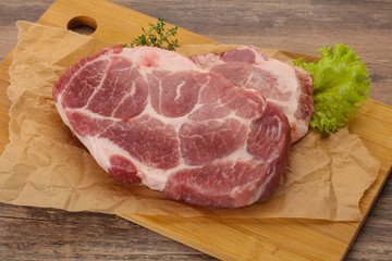 Raw pork steak over wooden board