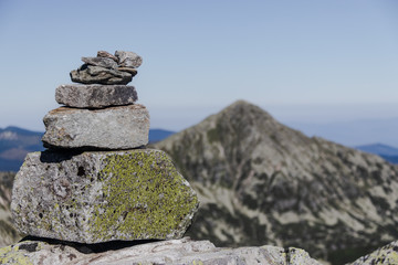 pile of rocks pointing towards mountain peak
