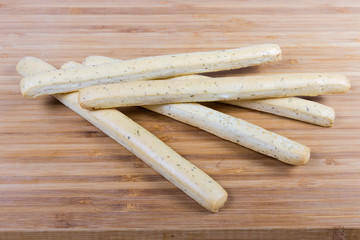 Breadsticks with Italian herbs on a wooden surface close-up