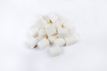 Fototapeta na wymiar Pile of the white refined sugar cubes on light surface