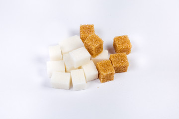 Pile of white and brown sugar cubes on light surface