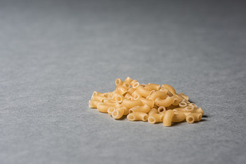 A pile of macaronis on grey background.