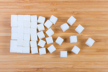 Top view of white sugar cubes on a wooden surface