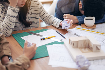 Group of an architect feel stressed after working on architecture model together with shop drawing...