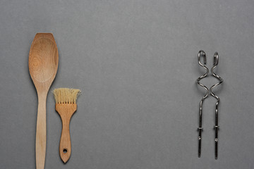 Wooden spoon and kneading hooks on grey background