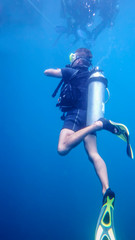 Under the water, the diver swims in the thickness of the sea water near the surface