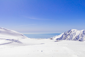 The japan alps  or the snow mountains wall  of Tateyama Kurobe alpine  in sunshine day with  blue sky background is one of the most important and popular natural place in Toyama Prefecture, Japan.