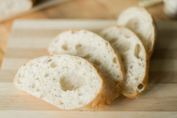 Sliced bread, ciabatta on wooden background. Preparation for the preparation of bruschetta.