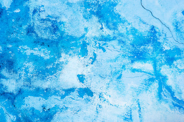 Grunge blue painted cracking plaster wall texture background.