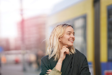 Happy woman in Berlin with tramway behind her. - obrazy, fototapety, plakaty