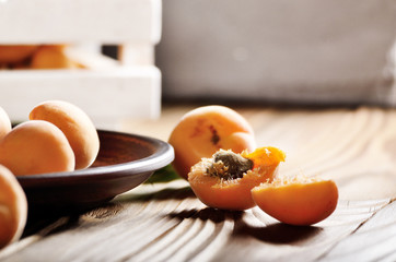 Clay dish with ripe apricots on wooden table