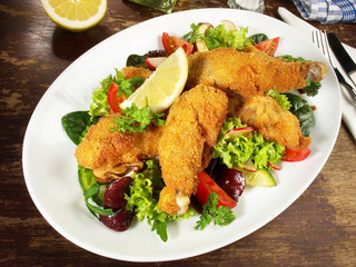 Backhendl mit Zitrone auf Salat