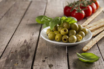Wooden surface with olives and tomatoes background