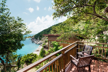 Fototapeta na wymiar paradise house in the jungle with an ocean view wooden terrace blue sea and mountains 