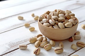 Bowl with pistachios on wooden background. Top view with copy space