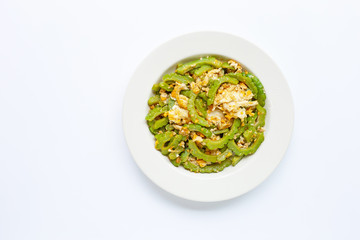 Stir-fried egg with bitter melon on a white dish on white background. Top view