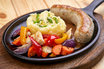 sausage with mashed potato and vegetables, wooden background