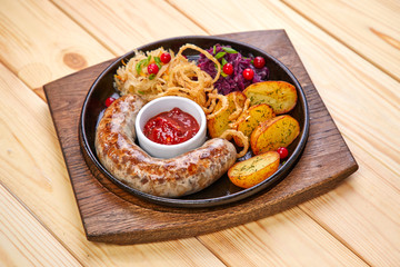sausage with baked potatoes and salad on the wooden background