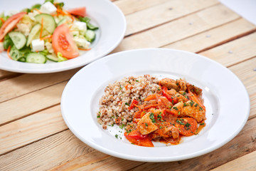meat with buckwheat and salad on the wooden background