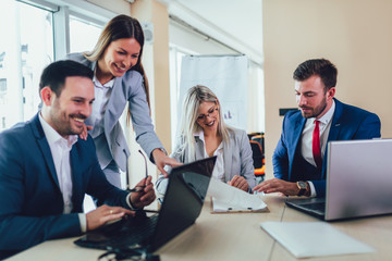 Creative business people working on business project in office using laptop.