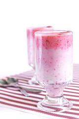 Vegetarian coconut milk cocktail with strawberry in white glass on white background