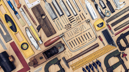 View of a set of carpenter's tools on a wooden background.