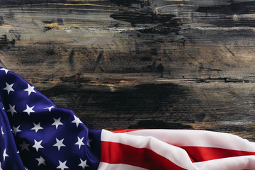 Patriotic composition w/ ruffled American flag, wood planks background. United States of America stars & stripes symbol, copy space for text. 4th of july Independence day concept. Background, close up