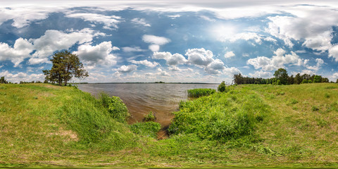 Fototapeta na wymiar full seamless spherical hdri panorama 360 degrees angle view on grass coast of huge lake or river in sunny summer day and windy weather with beautiful clouds in equirectangular projection, VR content