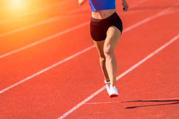 Young sporty woman running on sunny day