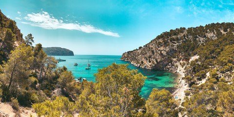 View from above of the beautiful Cala Blanca, Andratx with a turquoise waters  and spanish nature landscape with blue bright summer sky. Mallorca, Balearic Islands
