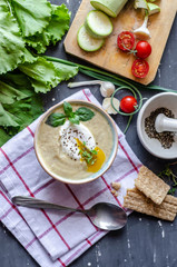 Healthy zucchini cream soup served with poached egg and greens. Proper nutrition food