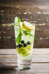Fresh summer cocktail with blueberry and kiwi on the wooden background. Selective focus. Shallow depth of field. 