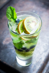 Fresh summer cocktail with blueberry and kiwi on the wooden background. Selective focus. Shallow depth of field. 