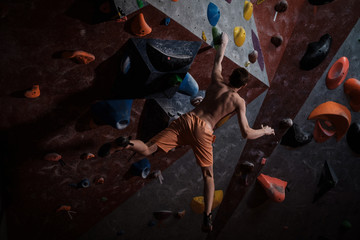 Athletic man practicing in a bouldering gym