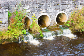 Toxic water running in concrete drainpipe towards the river