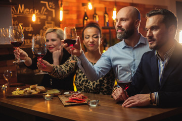 Group of friends having fun talk behind bar counter in a cafe
