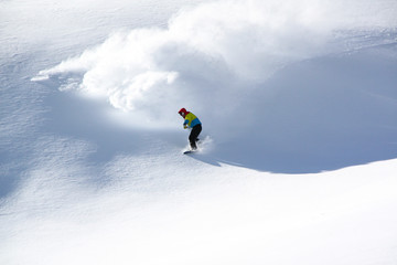 Naklejka na ściany i meble Snowboarder in fine white powder snow